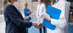 Two physicians shaking hands after one has been made partner at their practice